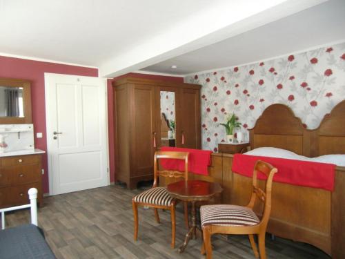 StadtlauringenにあるArnold´s Ferienhofのベッドルーム1室(ベッド1台、テーブル、椅子付)