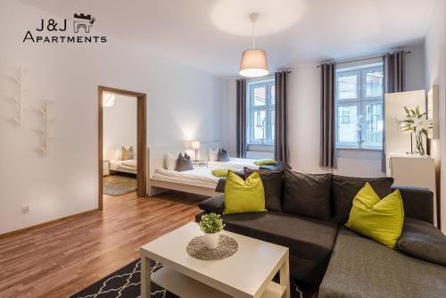 salon z kanapą i łóżkiem w obiekcie J&J Apartments, Szeroka 25 Apartament 7 w Toruniu