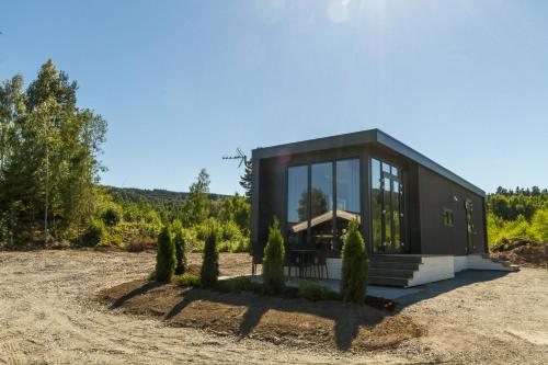 ein schwarzes Haus auf einem Feld mit Bäumen in der Unterkunft Sveastranda Camping in Gullor