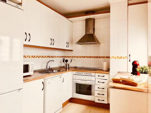 トレドにあるRecoletos 4の白いキャビネットとシンク付きのキッチン