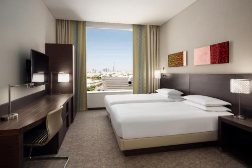 a hotel room with two beds and a window at Hyatt Place Riyadh Sulaimania in Riyadh