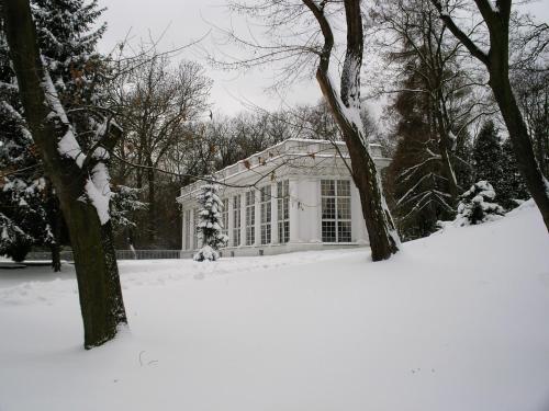 a house with a snow covered yard in front of it at Hotel butikowy Pałac Jabłonna in Jabłonna