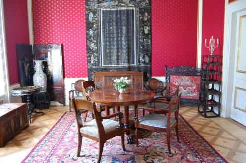 a dining room with a table and chairs and pink walls at Hotel butikowy Pałac Jabłonna in Jabłonna
