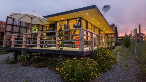 a house with an umbrella in front of it at Lodge KARKÚ in Pichilemu