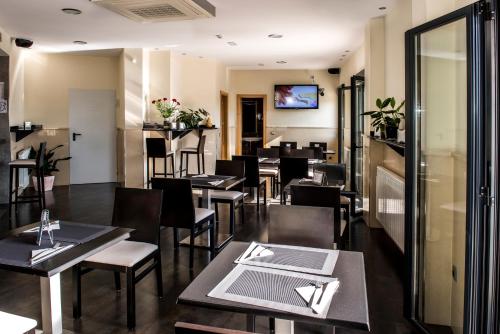 a restaurant with tables and chairs and a tv at Hotel Puerta de la Santa in Avila