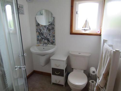 ein Badezimmer mit einem WC, einem Waschbecken und einem Spiegel in der Unterkunft Golden Oak Chalet in Dunbar