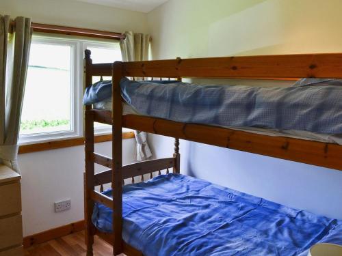 a bedroom with two bunk beds and a window at Golden Oak Chalet in Dunbar