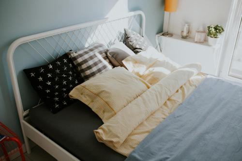 Una cama con almohadas y mantas. en NG New Gardens Apartment, en Poznan