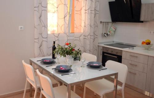 a kitchen with a table with four chairs and a table and a table at Pyramid City Apartments in Agios Spyridon Corfu