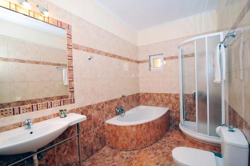 a bathroom with a tub and a sink and a toilet at Pyramid City Apartments in Agios Spyridon Corfu
