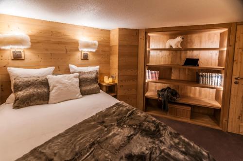 ヴァル・トランスにあるVal Thorens - Cosy Duplex avec Vue Silveralp 341の大きなベッドと木製の壁が備わるベッドルーム1室が備わります。