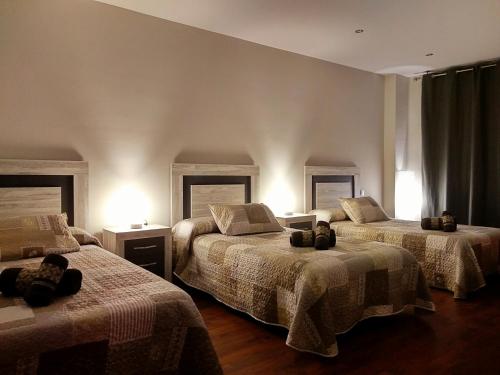 a bedroom with two beds and two lights at Casa Rural El Caño in Nava del Rey