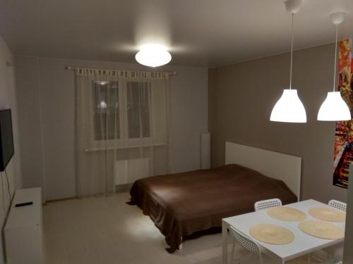 チュメニにあるАпартаменты на Таврической 9 корпус 5のベッドルーム1室(ベッド1台、テーブル、2つの照明付)