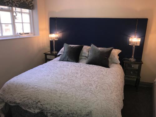 a bedroom with a large bed with two lamps at The Flat Axbridge in Axbridge