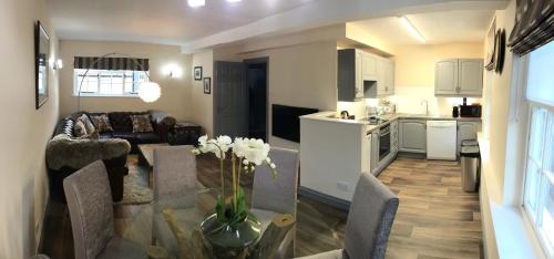 a kitchen and living room with a couch and a table at The Flat Axbridge in Axbridge