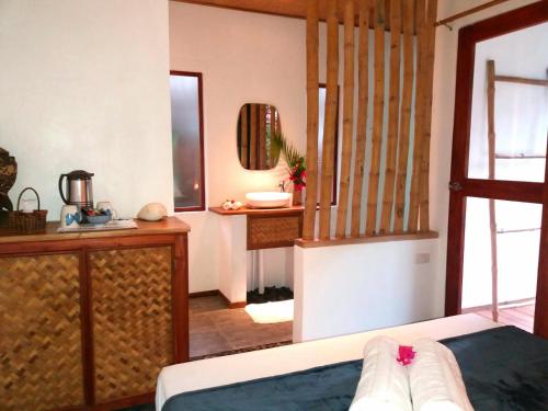 サン・ヴィチェンテにあるValerie Lodgeのベッド、洗面台、鏡が備わる客室です。