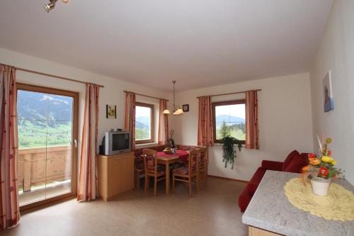 Una sala de estar con cocina y comedor. en Bauernhof Hundbichl, en Brixen im Thale