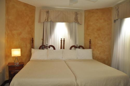una camera da letto con un grande letto bianco e una finestra di Beach PentHouse A25 Sandcastles a Ocho Rios