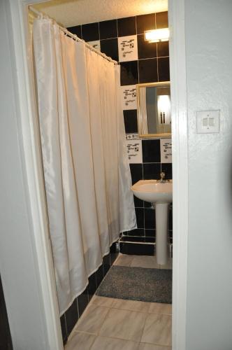 a bathroom with a white shower curtain and a sink at Beach PentHouse A25 Sandcastles in Ocho Rios