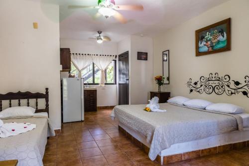 a bedroom with two beds and a refrigerator at Moonshine Hotel in Playa del Carmen