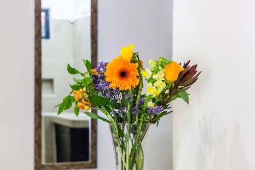 a vase of flowers sitting on a table in front of a mirror at Moonshine Hotel in Playa del Carmen