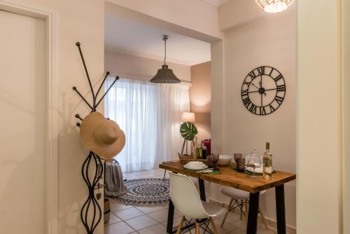 una sala da pranzo con tavolo e orologio sul muro di Acropolis, Urban Lifestyle apartment ad Atene