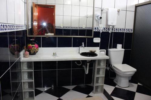 uma casa de banho com um lavatório e um WC em Hotel Takana em Tabatinga