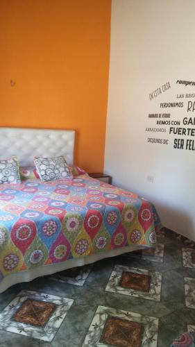 a bed with a colorful comforter in a room at Shalom in Mina Clavero