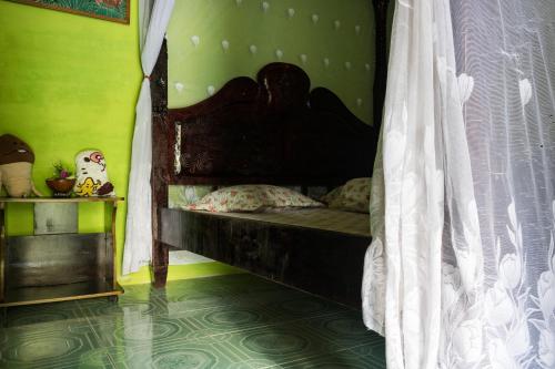 a bedroom with a wooden bed in a room at Rain Forest Guest House and Jungle Trekking in Bukit Lawang