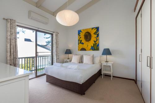 a bedroom with a bed and a large window at Cottesloe Sea Salt Abode in Perth