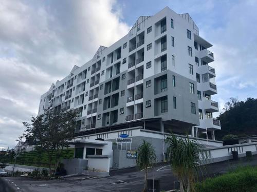 a large white apartment building with a parking lot at Brand New Apartment in Local Neighbourhood in Ringlet