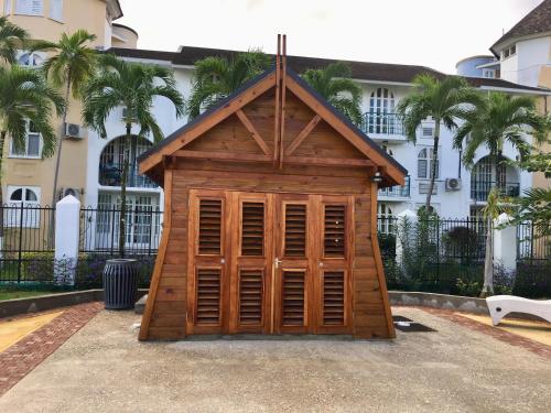a small wooden out house in front of a building at Castle by the Shore in Ocho Rios