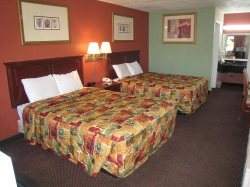 a hotel room with two beds and a desk at Motel 8 Maricopa in Maricopa