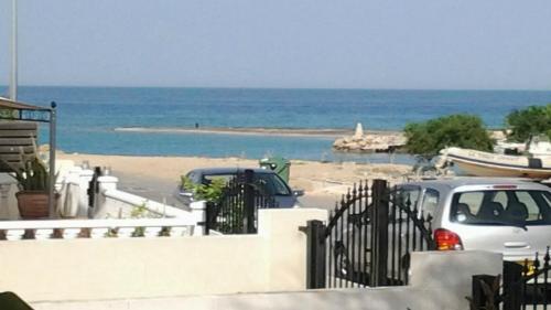 two cars parked in a parking lot next to the beach at Villa Emiliana in Paralimni