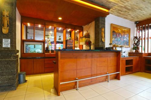 a large room with a bar with wooden cabinets at Hotel Sinar Bali Legian in Legian