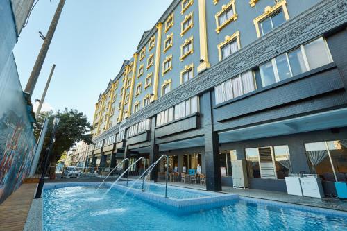 a building with a swimming pool in front of a building at Fulidun Hotel Kenting in Hengchun