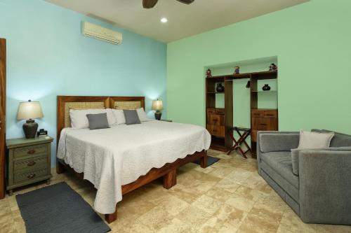a bedroom with a bed and a couch at Villas Piedra Blanca in Sayulita