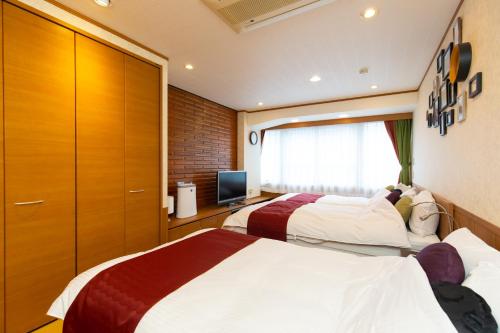 a hotel room with two beds and a television at Matsui Building in Tokyo