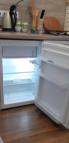 un frigorifero vuoto con la porta aperta in una cucina di Transfer apartment a Lviv