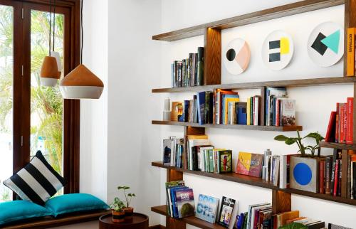 a living room with bookshelves and a book shelf at SALT of Palmar, an adult-only boutique hotel in Belle Mare