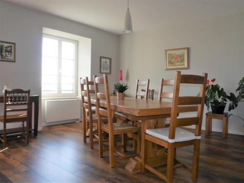 une salle à manger avec une table et des chaises en bois dans l'établissement Les gîtes de la Tour, appartement 