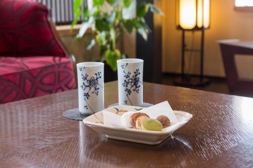 a plate of food on a table with two cups at Migiwatei Ochi Kochi in Fukuyama