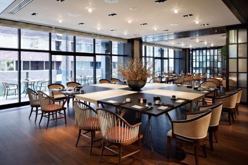 a dining room with tables and chairs and windows at Hyatt Centric Ginza Tokyo in Tokyo