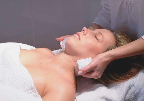 a woman laying on a bed with a towel at Der Grüne Baum in Sinsheim