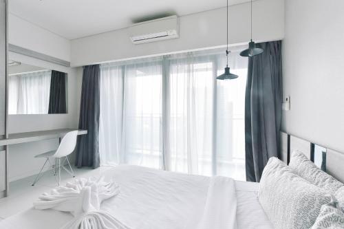 1 dormitorio con cama blanca y ventana en Summer Suites Residences by Subhome, en Kuala Lumpur