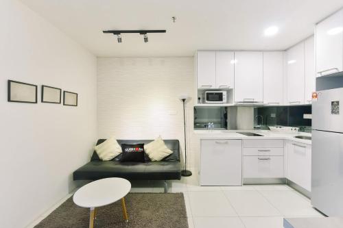 a living room with a couch and a kitchen at Summer Suites Residences by Subhome in Kuala Lumpur
