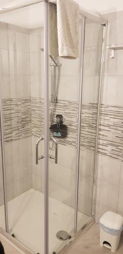 a shower with a glass door in a bathroom at House 149 in Ferrara