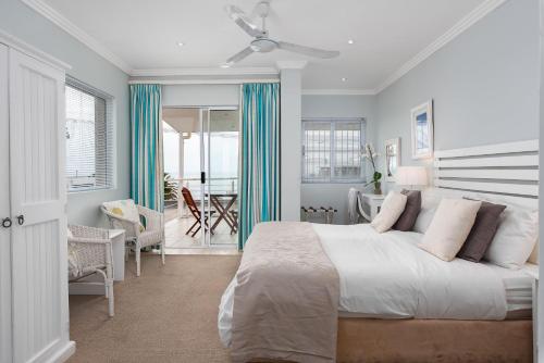 a bedroom with a large bed and a dining room at 61 on Camps Bay in Cape Town