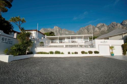 a white house with mountains in the background at 61 on Camps Bay in Cape Town