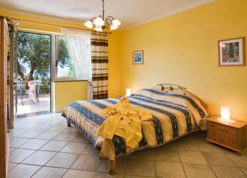 a bedroom with a bed with yellow walls and a window at Agriturismo La Pergola in Ischia